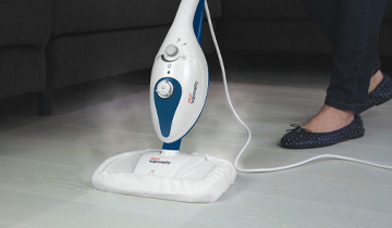 La photo montre le Polti Vaporetto SV210 nettoyant un sol en céramique à la vapeur