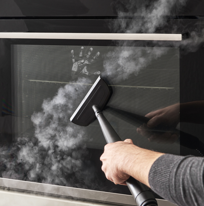 une personne nettoyant le miroir du four