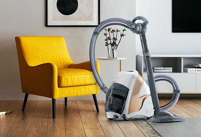 L'image montre la brosse Polti Unico dans un salon avec un fauteuil jaune