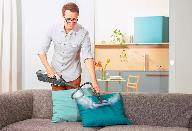 L'image montre Polti Vaporetto Style en mode nettoyeur vapeur portable utilisé sur des coussins en tissu